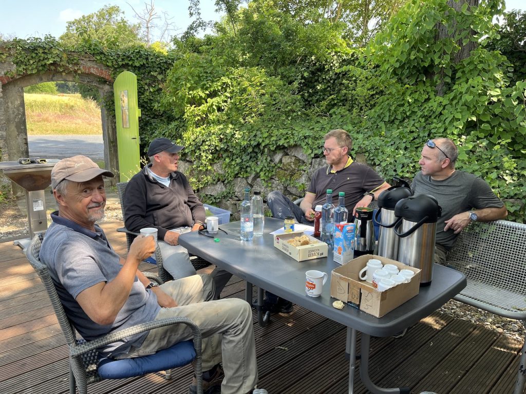 Vier Männer machen Kaffeepause an einem Tisch